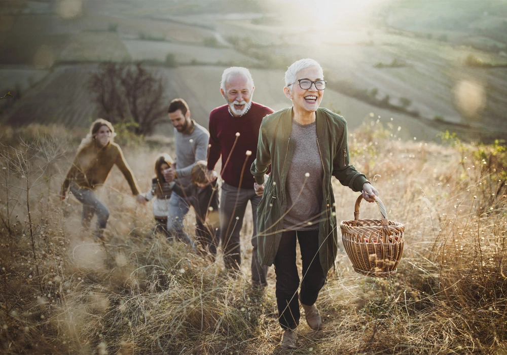 Eine Familie spaziert fröhlich durch eine sonnige Wiese