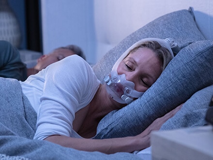 Eine Patientin trägt eine ResMed AirFit F30i Full Face Maske.