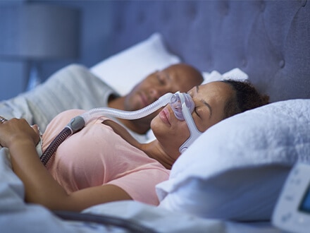 Eine schlafende Patientin trägt die ResMed AirFit™ N20 Nasenmaske.