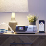 airsense-11-autoset-von-resmed-mit-cpap-maske-auf-nachttisch