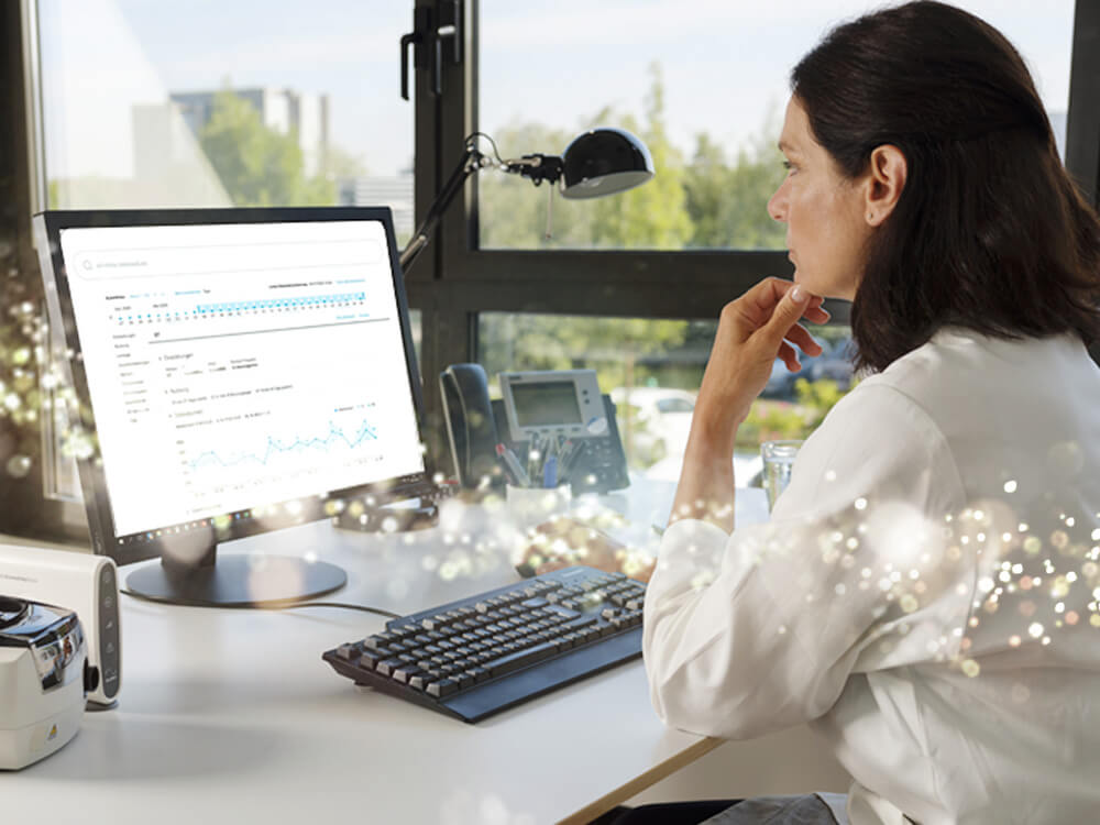 Ärztin sitzt an Computer mit AirView
